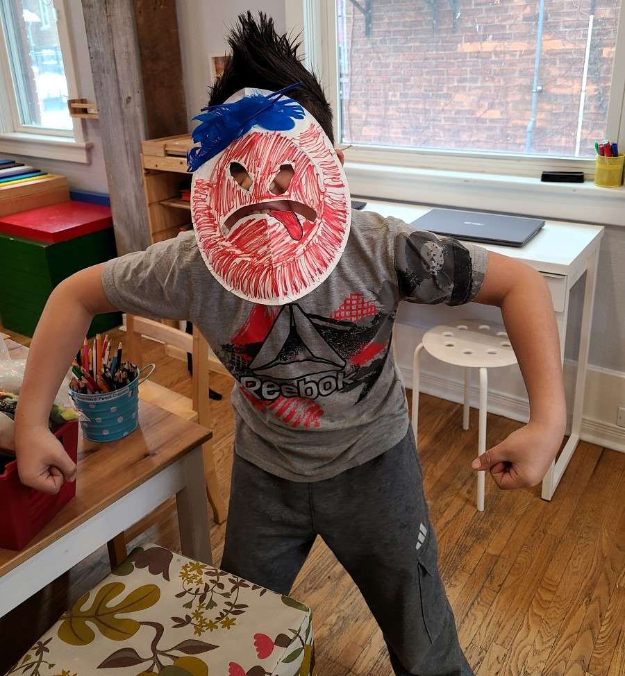 Lyonsgate Montessori School Elementary student with a theatre mask made as part of their ancient Greek studies.