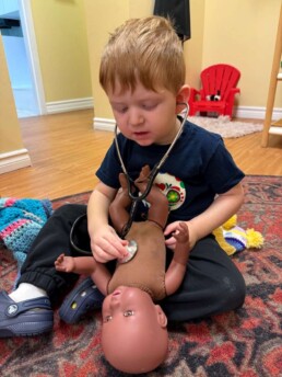 Lyonsgate Montessori School Toddler student caring for the baby doll using the stethoscope!