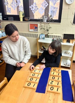 Lyonsgate Montessori School Casa student receiving a presentation of the Montessori Teen Boards material.