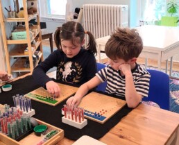 Lyonsgate Montessori School Elementary students working on division together with the Montessori Racks and Tubes material.