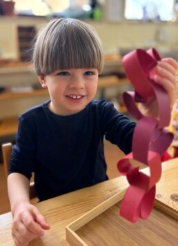 Lyonsgate Montessori School Casa student making a Valentine's Day craft.