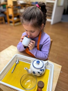 Lyonsgate Montessori School Casa student enjoying a cup of tea she successfully followed the steps to make.