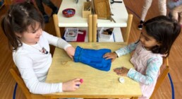 Lyonsgate Montessori School Casa students developing their tactile sense by identifying objects by feel with the Montessori Mystery Bag material.