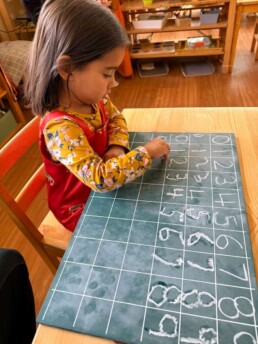 Lyonsgate Montessori School Casa student practicing writing numbers 0-9.