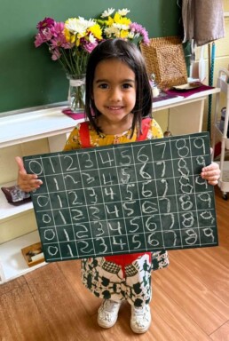 Lyonsgate Montessori School Casa student displaying her writing numbers 0-9 work.