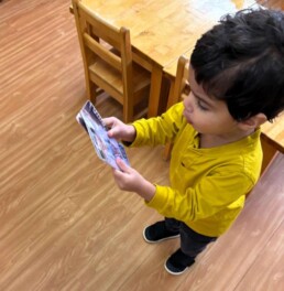 Lyonsgate Montessori School Toddler student recognizing and comparing his classmates from a picture to them in real life.