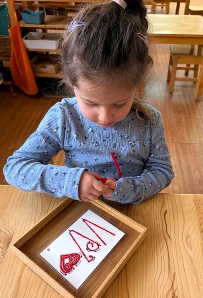 Lyonsgate Montessori School Casa student building some exquisite fine motor skills with a pipe cleaner craft.