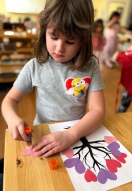 Lyonsgate Montessori School Casa student making a Valentine's Day craft.