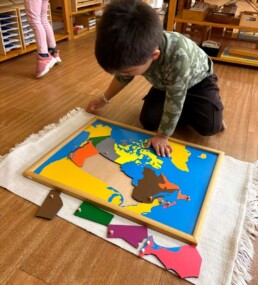 Lyonsgate Montessori School Casa student working with the Montessori Puzzle Map of Canada material.