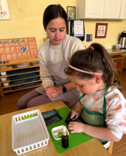 Lyonsgate Montessori School Casa student learning to follow a prescribed sequence of steps to achieve an observable goal with a Montessori Polishing activity.