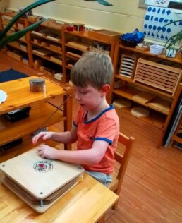 Lyonsgate Montessori School Casa student with the classroom's flower and plant press.