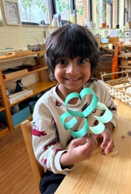Lyonsgate Montessori School Casa student with a shamrock craft created in celebration of St. Patrick's day which fell during the March Break.