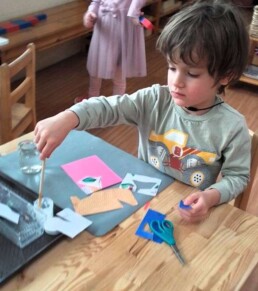 Lyonsgate Montessori School Casa student working on a little old school cut and paste.