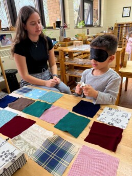 Lyonsgate Montessori School Casa student refining his tactile sense by matching fabrics that feel the same.