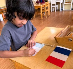 Lyonsgate Montessori School Casa student creating a flag, and learning about countries and fractions at the same time.