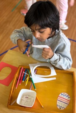Lyonsgate Montessori School Casa student creating an Easter craft while working with the Montessori Metal Inset material.