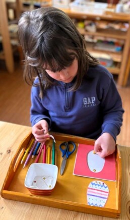 Lyonsgate Montessori School Casa student creating an Easter craft while working with the Montessori Metal Inset material.