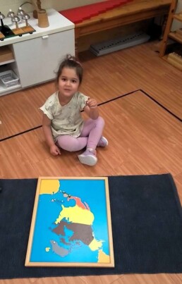 Lyonsgate Montessori School Casa student completing the Montessori Puzzle Map of North America.