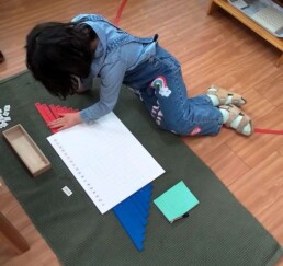 Lyonsgate Montessori School Casa student setting up the Montessori Addition Strip Board material.