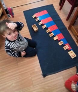 Lyonsgate Montessori School Casa student giving the thumbs up for some successful Montessori Number Rods work.