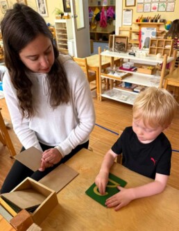 Lyonsgate Montessori School Casa student receiving a presentation of the Montessori Sandpaper Numerals material to begin building knowledge of how to form number symbols.