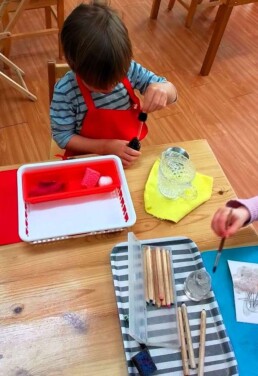 Lyonsgate Montessori School Casa student engaged in a Montessori Polishing activity that builds motor control, concentration, and the reward of observable success achieved by following prescribed steps.