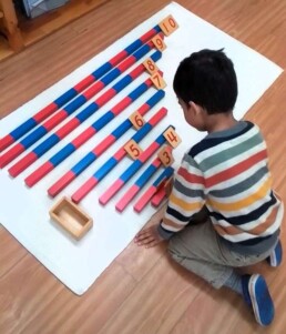 Lyonsgate Montessori School Casa student working with the Montessori Red Rods and Numerals material.