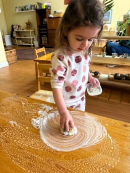Lyonsgate Montessori School Toddler student washing tables and chairs in the classroom, an activity that teaches a practical skill and demonstrates the success achieved by following prescribed steps.