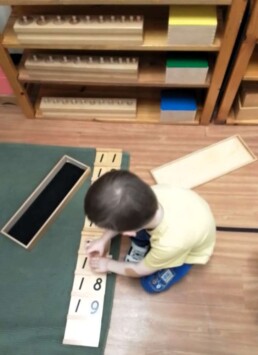 Lyonsgate Montessori School Casa student using the Montessori Teen Boards material to build the teen numbers.