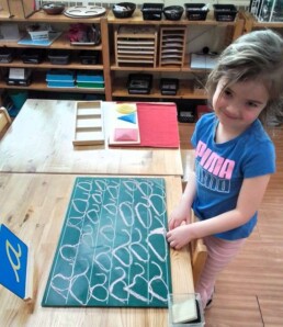 Lyonsgate Montessori School Casa student taking her first steps into writing.