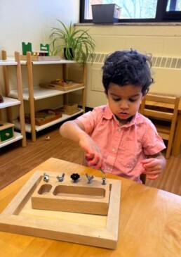 Lyonsgate Montessori School Toddler student developing fine motor skills with different types of fasteners.