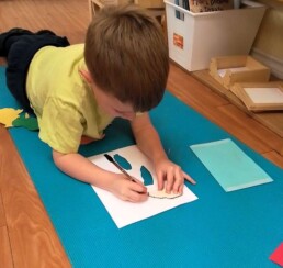 Lyonsgate Montessori School Casa student tracing parts of a Montessori Puzzle Map to
