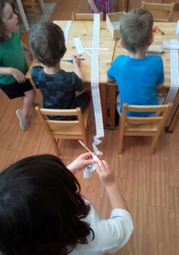 Lyonsgate Montessori School Casa student working on her number roll -- an exciting step for Casa students as their roll gets bigger as they keep adding to it as they count to and write down ever higher numbers.