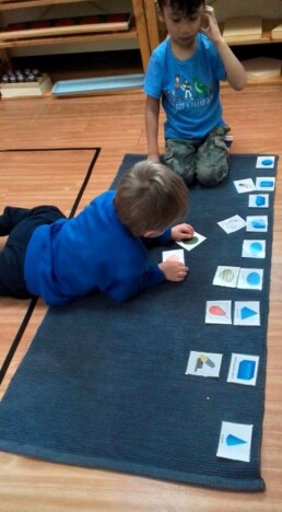 Lyonsgate Montessori School Casa students matching images of real-world objects to images of matching geometric shapes.