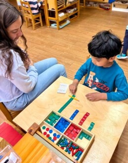 Lyonsgate Montessori School Casa student receiving a presentation of the Montessori Stamp Game material to learn addition.