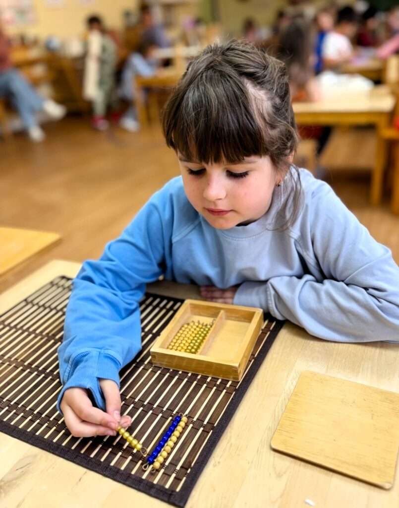Lyonsgate Montessori School Casa student progressing through the world of numeracy with the Montessori Teen Beads material.