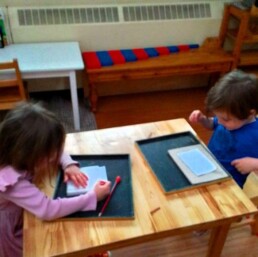 Lyonsgate Montessori School Casa students working together during their Montessori work cycle.
