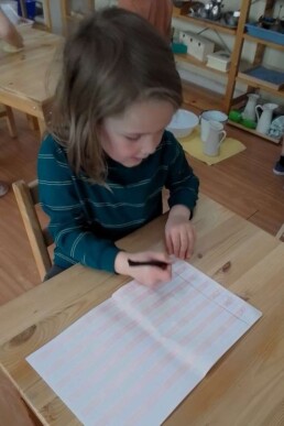 Lyonsgate Montessori School Casa student embarking on some cursive writing practice.