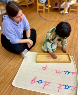 Lyonsgate Montessori School Casa student entering the world of writing with the Montessori Moveable Alphabet material.