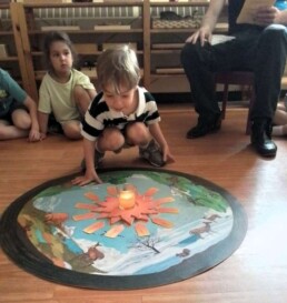 Lyonsgate Montessori School Casa student celebrating his birthday by taking trips around the sun, then blowing it out.