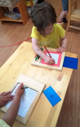 Lyonsgate Montessori School Casa students developing their pincer grips, focus, and fine motor control with the Montessori Metal Insets material.