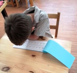 Lyonsgate Montessori School Casa student putting in the work to master cursive letters.